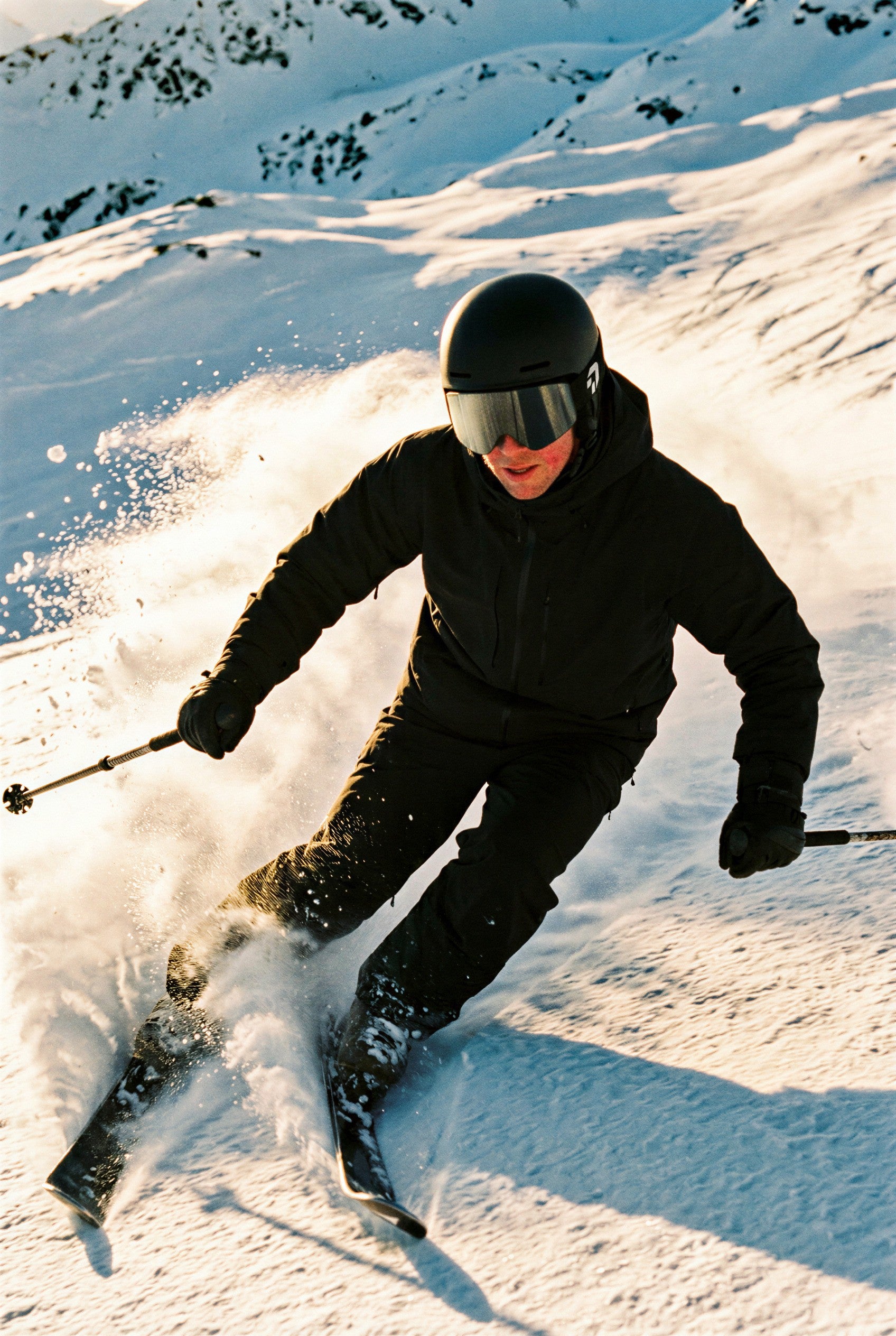 Skiër met de zwarte skibril van Create Performance snijdt een bocht door de verse sneeuw